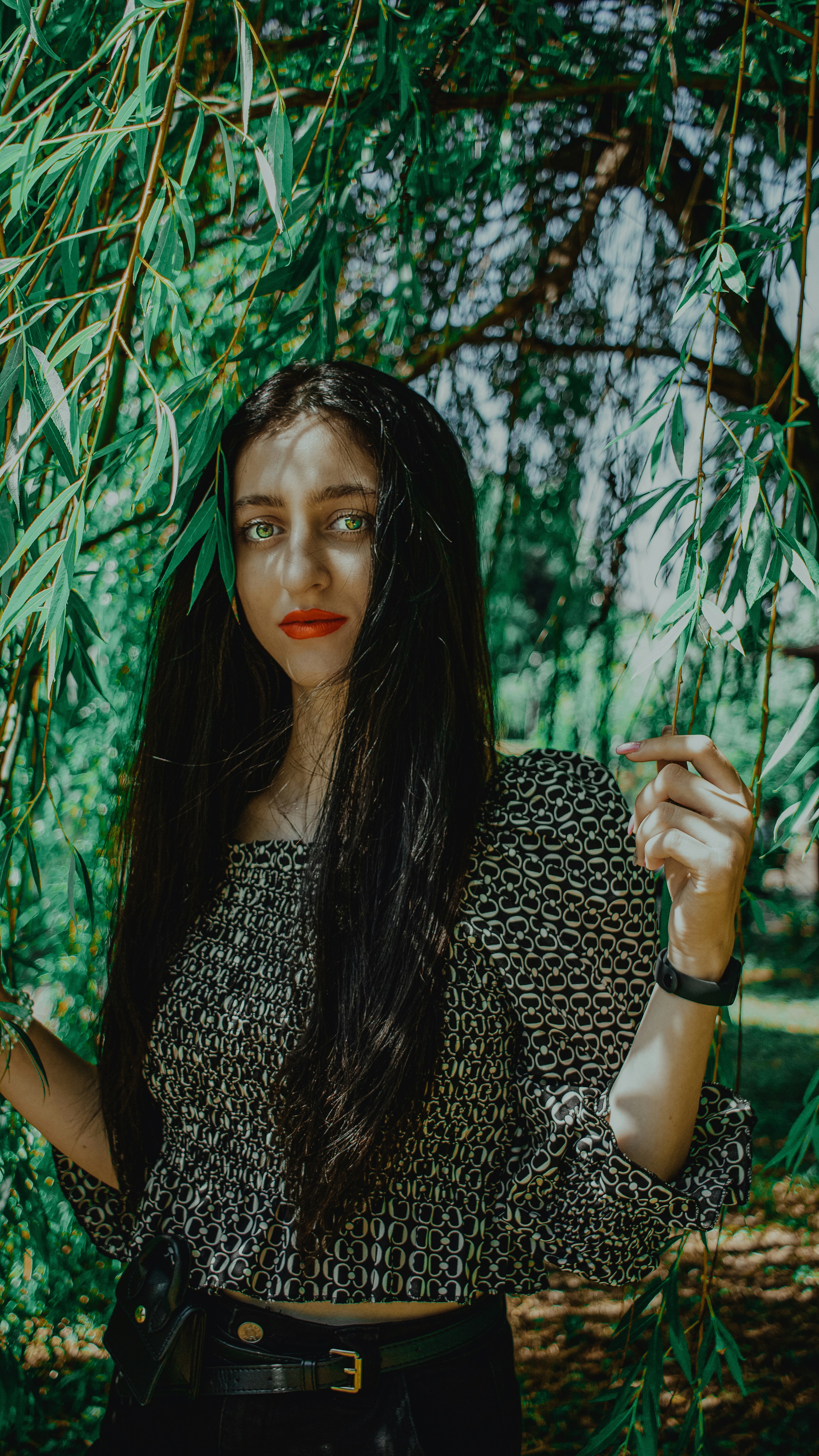 woman in black and white leopard print dress standing near green leaf plant during daytime